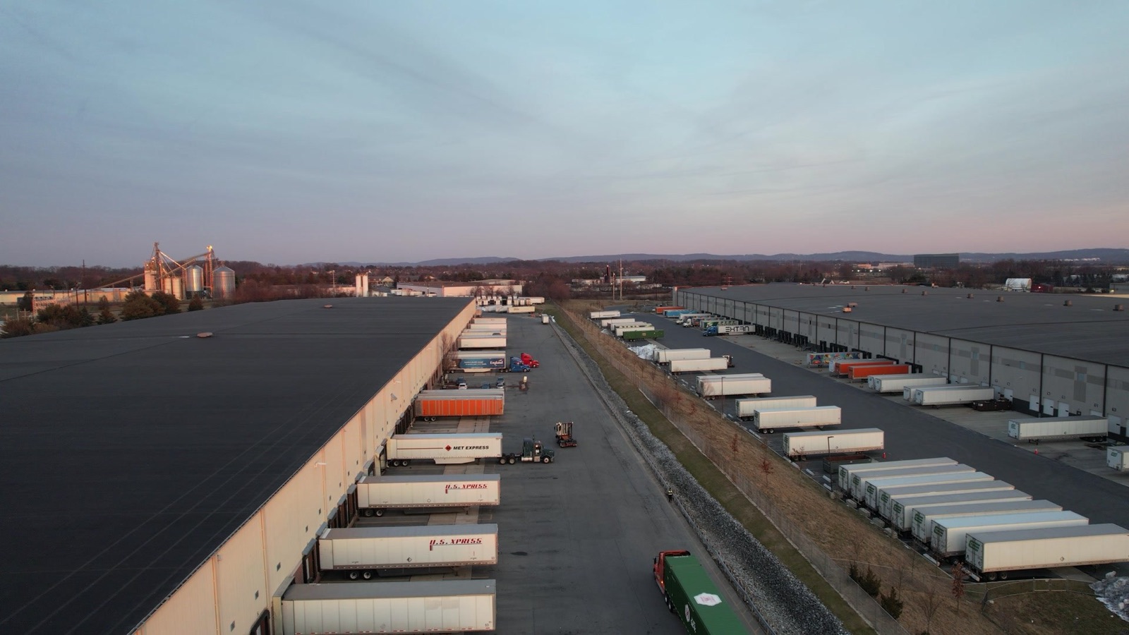 Distribution center dock doors and trailers at dusk